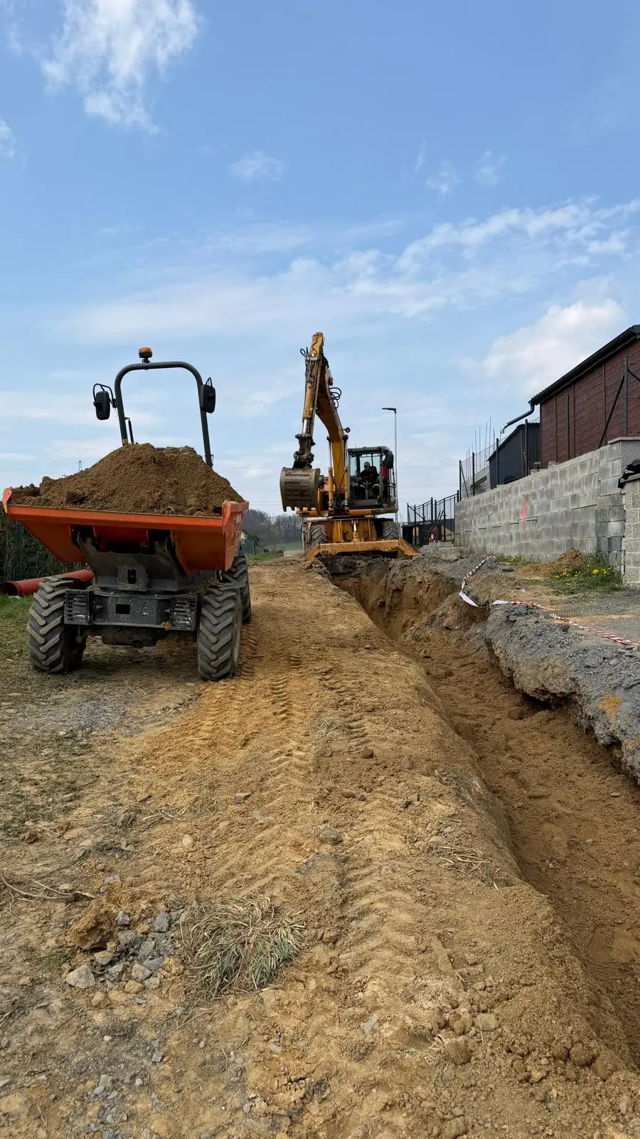 Otevřená kanalizační rýha s rypadlem a otočným dumperem